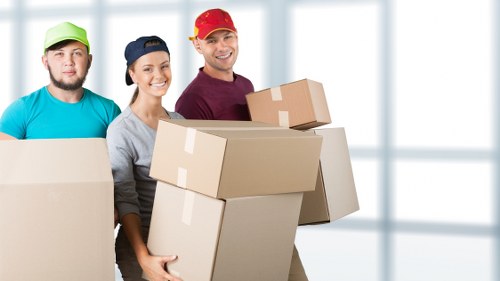 Removal staff handling desks and office boxes carefully