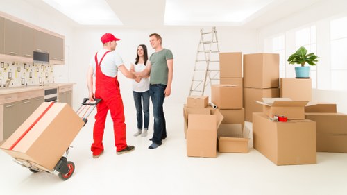Movers carrying items through a local Tottenham flat building